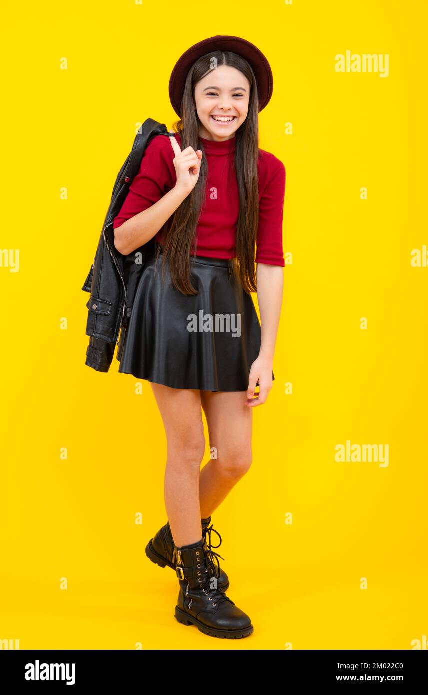 Toute la longueur d'une jeune fille adolescente gaie portant une jupe en  cuir tendance confortable, isolée sur fond jaune. Joyeux portrait d'adolescent.  SMIL Photo Stock - Alamy