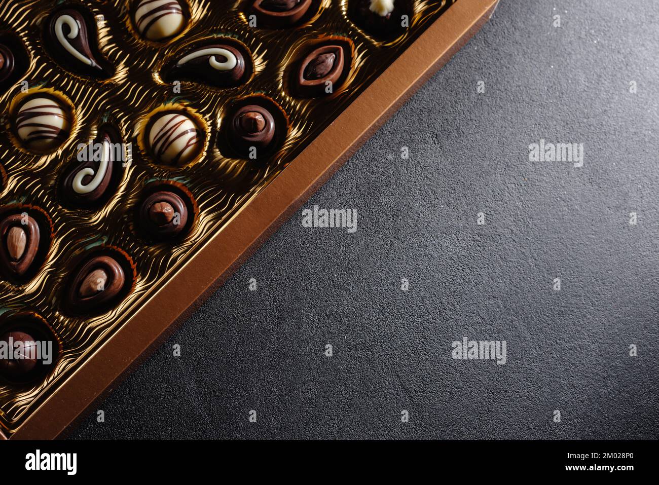 Une boîte de chocolats différents. Assortiment de chocolat sur la table noire, vue du dessus. Copier l'espace. Banque D'Images