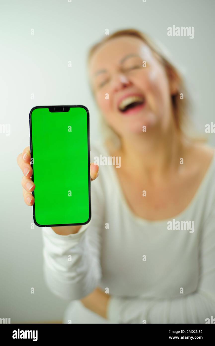 Gagner pour trouver ce qui à rechercher la joie bonheur différentes émotions Chroma Key téléphone vert écran espace pour la publicité belle femme heureuse adulte Banque D'Images