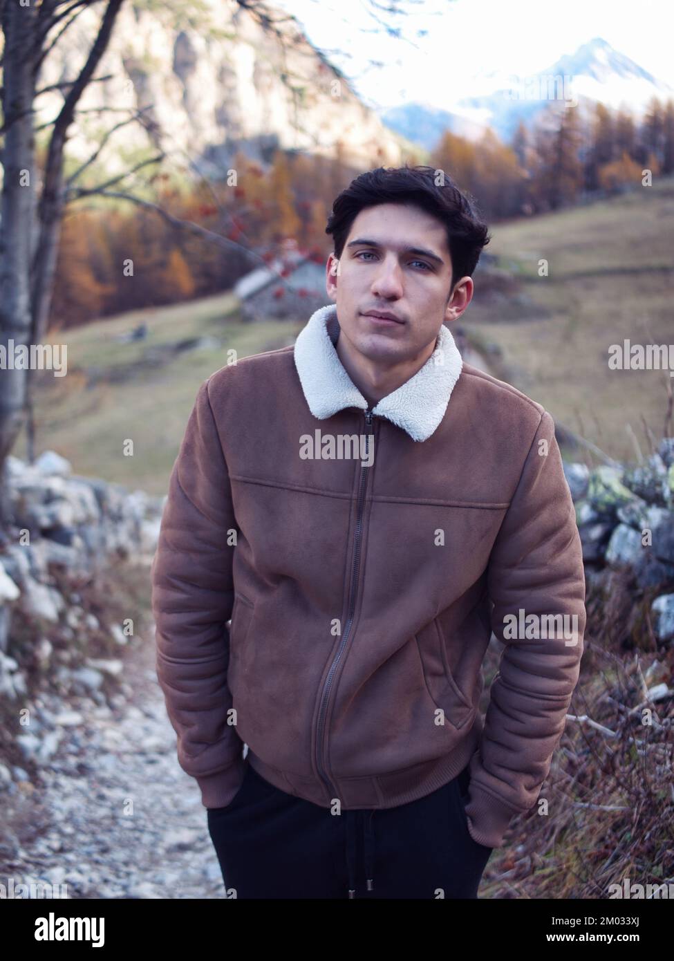 Jeune homme attrayant dans les montagnes en automne ou en hiver, temps  froid, portant une veste en daim, regardant l'appareil photo Photo Stock -  Alamy