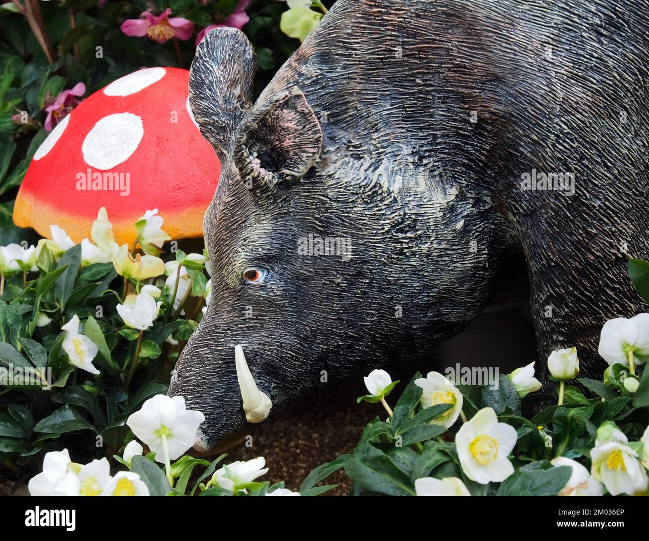 Sculpture d'un sanglier dans un jardin fleuri Banque D'Images