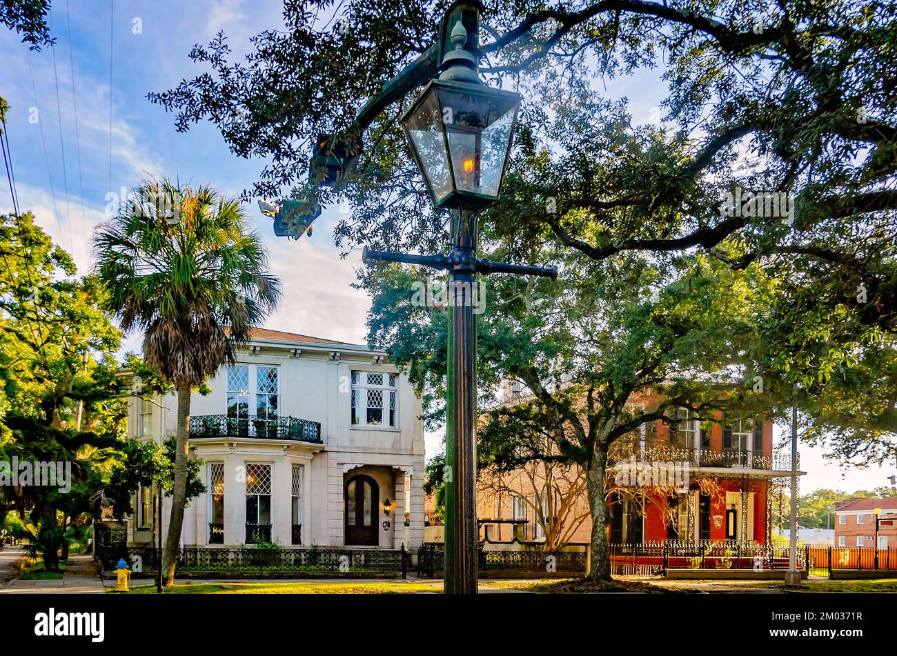 Une lampe de rue à gaz brûle devant les maisons historiques dans le quartier historique de Church Street East sur Government Street, le 30 novembre 2022, à Mobile, Alabama. Banque D'Images