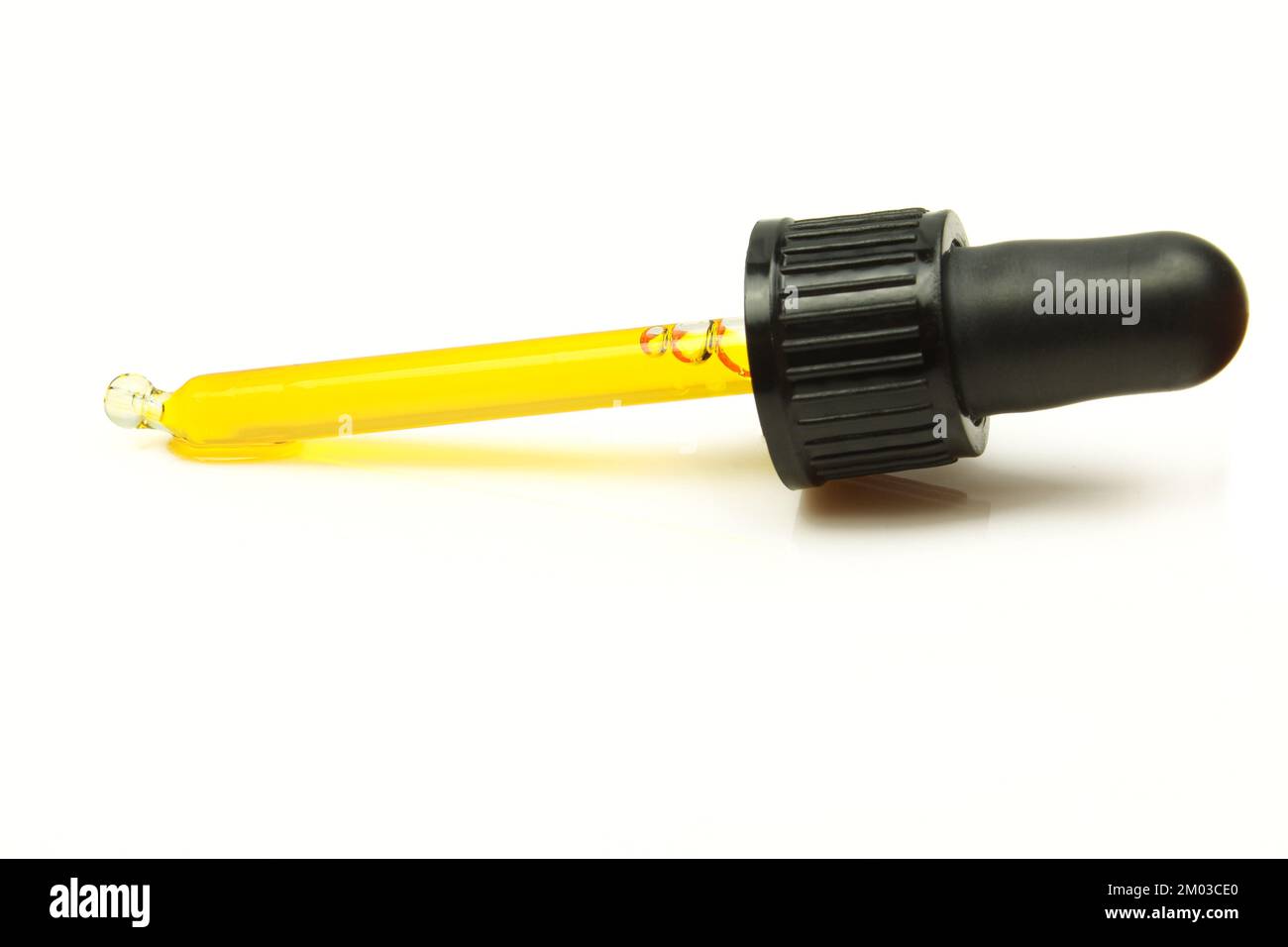 Pipette à huile isolée sur fond blanc. Extrait d'essence naturelle de substance jaune dans compte-gouttes Banque D'Images