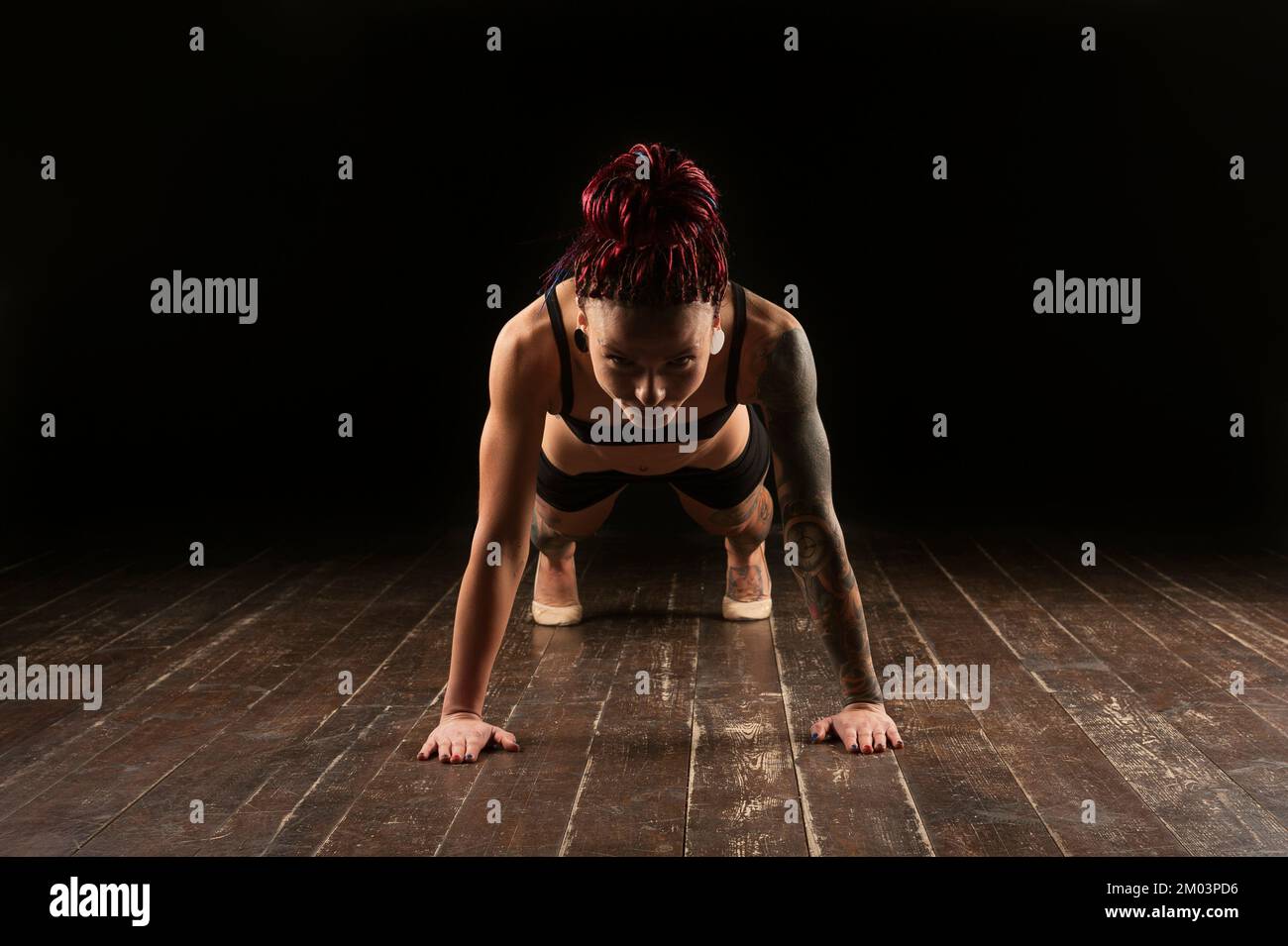 Pleine longueur de jeune athlète pratiquant le yoga en studio sur fond noir, Banque D'Images
