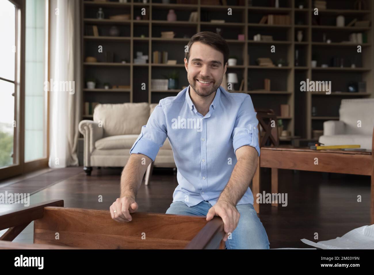Heureux acheteur de meubles d'assemblage de pièce en bois à la maison Banque D'Images