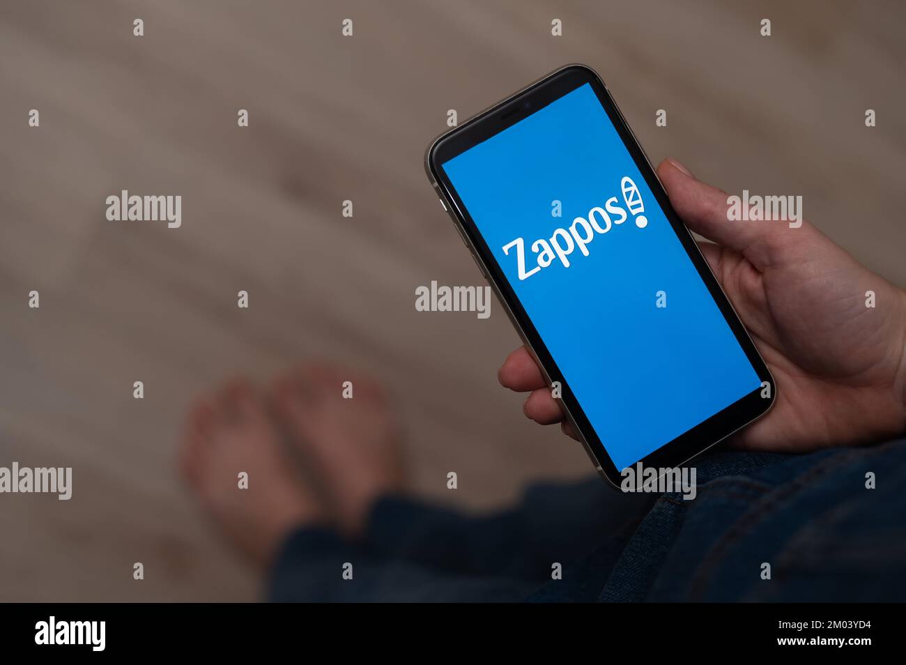 3 décembre 2022 Almaty Kazakhstan: Femme pieds nus tenant un smartphone avec le logo zappos. Banque D'Images 3 décembre 2022 Almaty Kazakhstan: Femme pieds nus tenant un smartphone avec le logo zappos. Banque D'Images