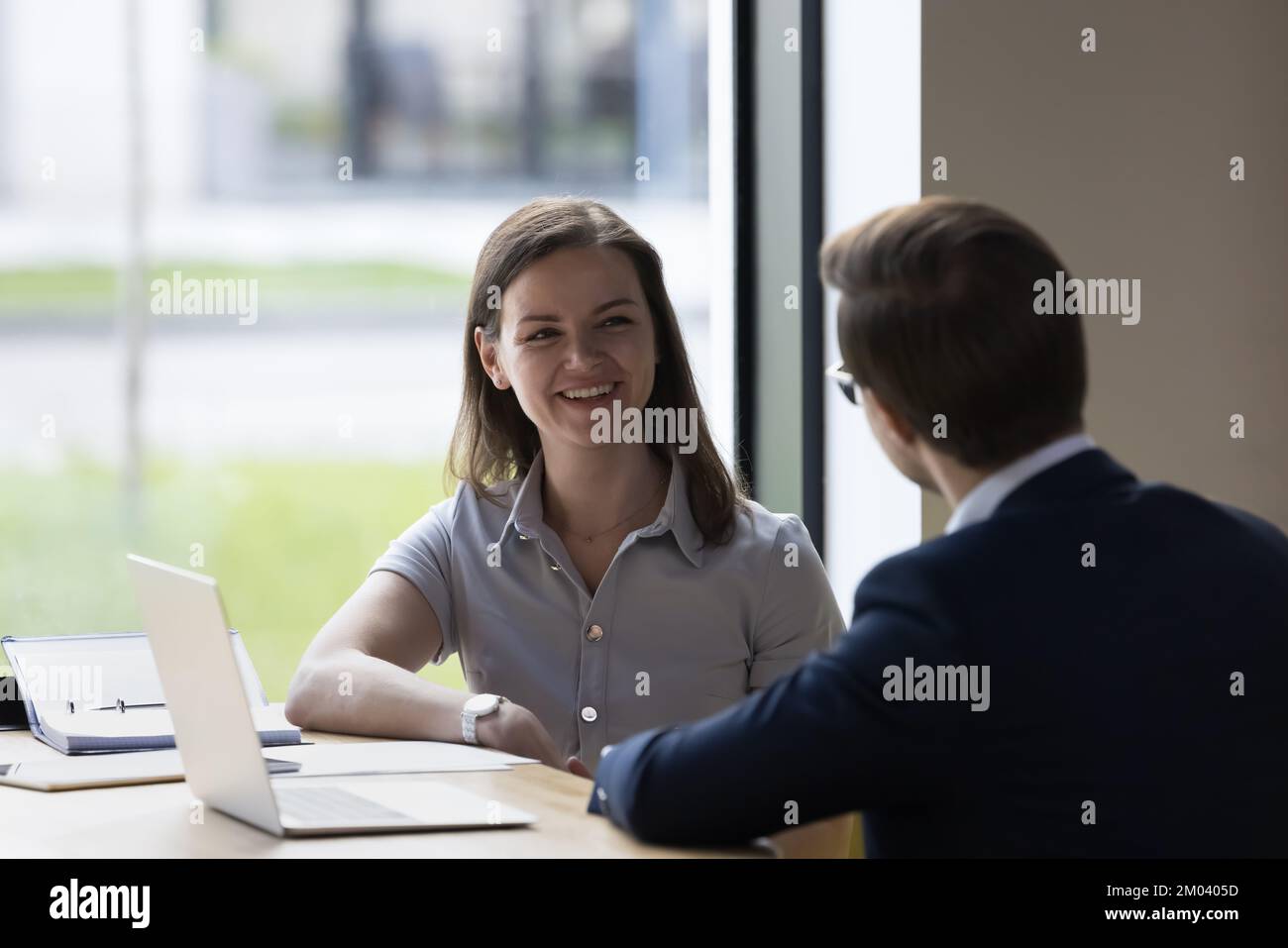 Collègues communiquant assis à leur bureau dans un espace de travail moderne Banque D'Images