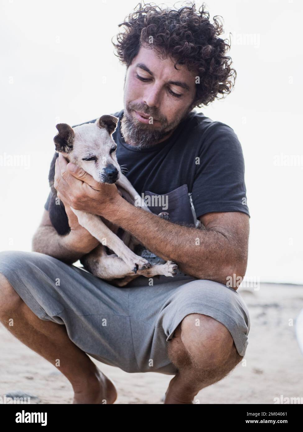 Homme caucasien tenant son vieux petit chien malade Banque D'Images