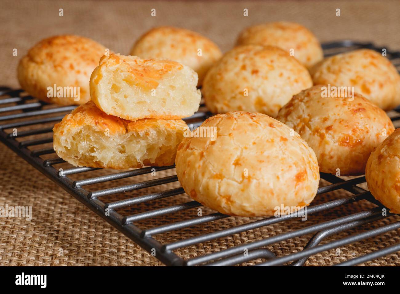 Gros plan du pain au fromage sur la grille de refroidissement. Boules de pain au fromage brésilien traditionnel en gros plan sur fond rustique Banque D'Images