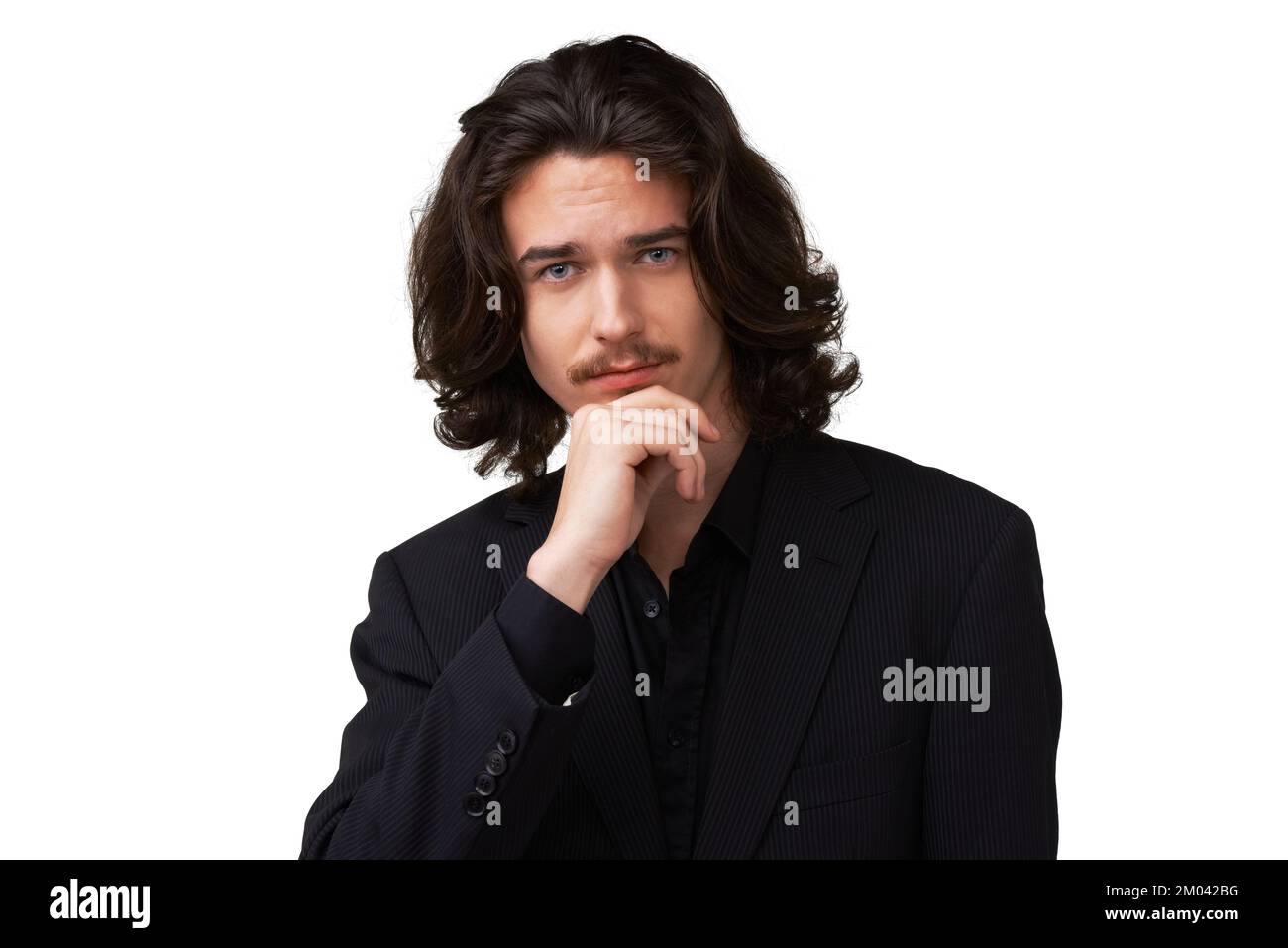 Sombre, beau et mystérieux. Beau jeune homme posant avec sa main sur son menton - isolé. Banque D'Images