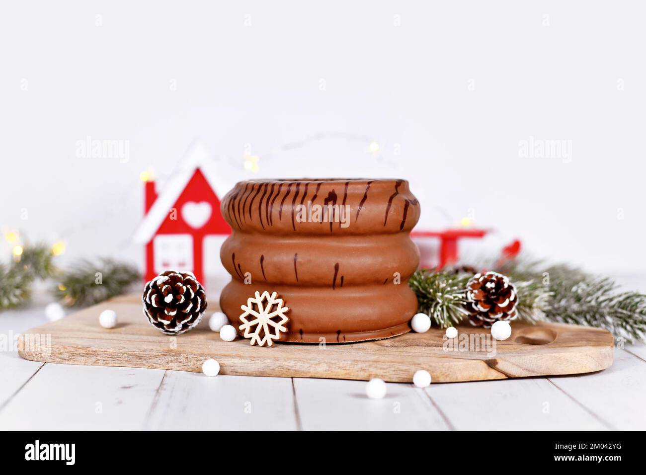 Gâteau appelé 'Baumkuchen', une pâtisserie traditionnelle allemande superposée d'hiver émaillée de chocolat, entouré par la décoration de saison Banque D'Images