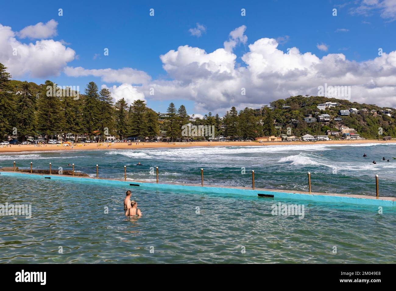 Palm Beach Sydney, les gens dans la piscine de l'océan avec vue sur la plage et la frange des pins norfolk, NSW, Australie Banque D'Images