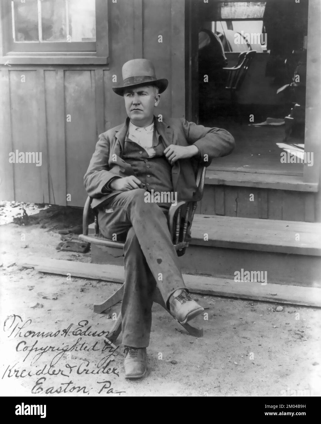 Thomas Alva Edison, 1847-1931, portrait pleine longueur, assis dans une chaise pivotante à l'extérieur du bureau, face à gauche 1895 Banque D'Images