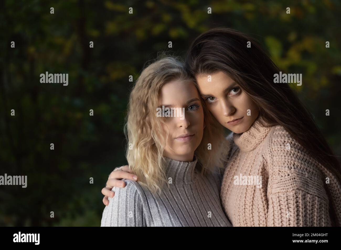 Portrait de deux belles filles posant pour l'appareil photo à l'extérieur. Horizontalement. Banque D'Images