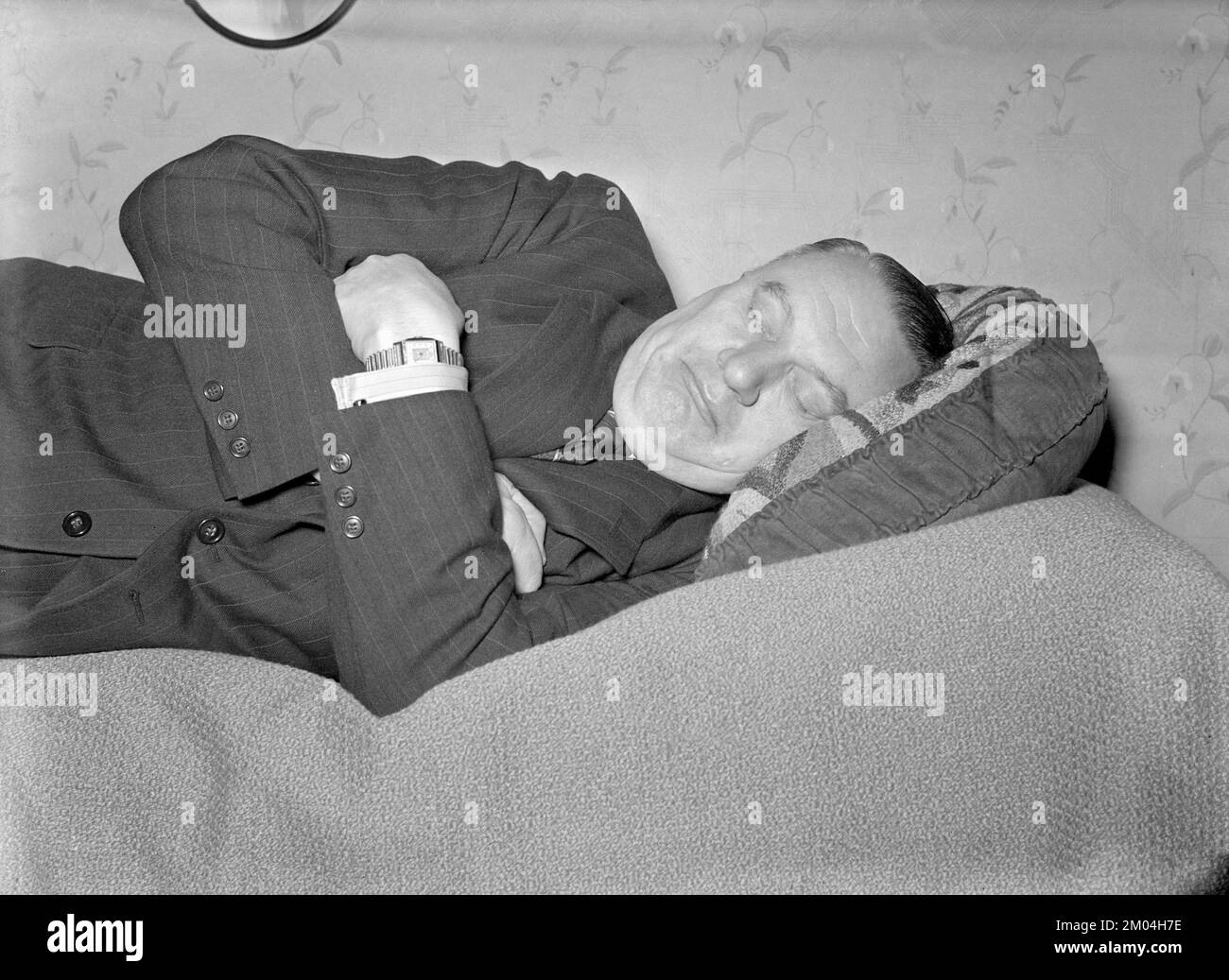 Avoir une sieste dans le 1940s. Un homme fatigué est couché sur le lit ayant une sieste. Suède 1947. Kristoffersson réf. 42-6 Banque D'Images