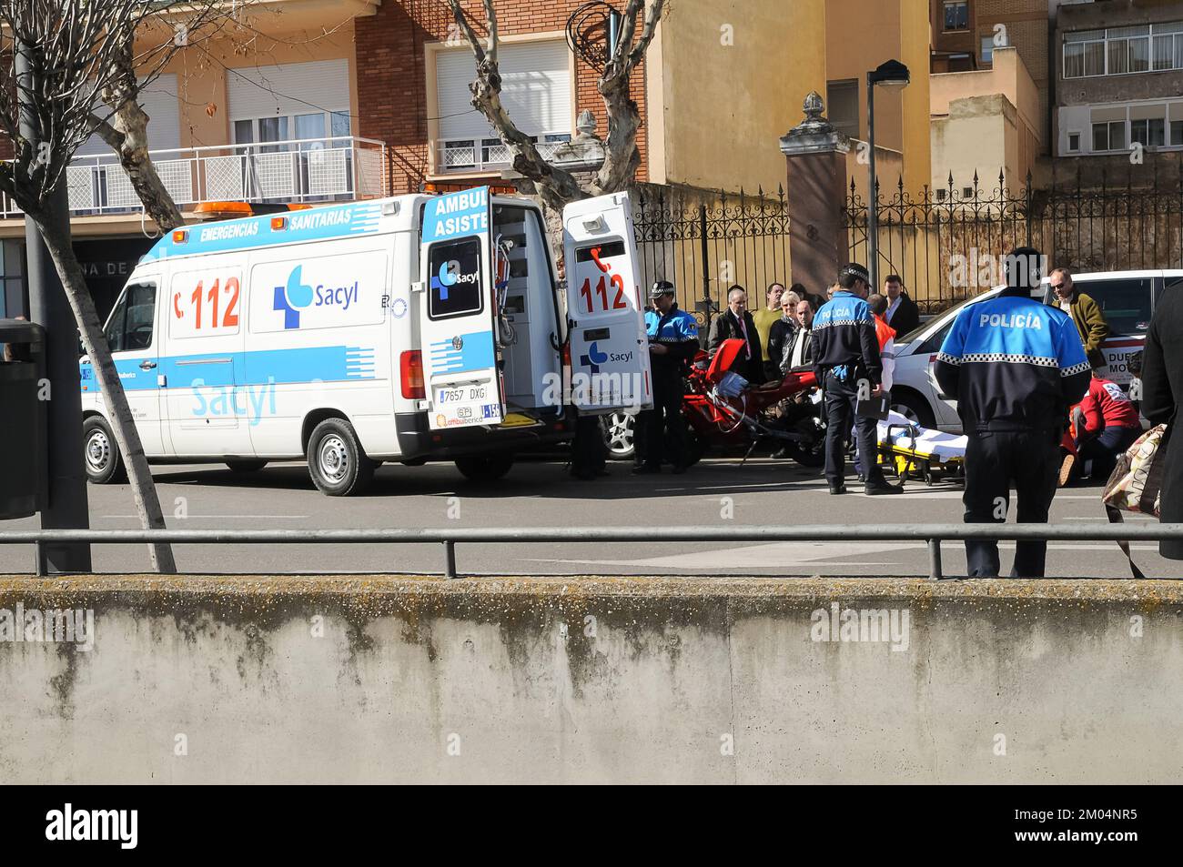 Ambulance attendant de prendre une personne blessée d'un accident de la route devant les yeux des policiers et des gens de la ville. Banque D'Images