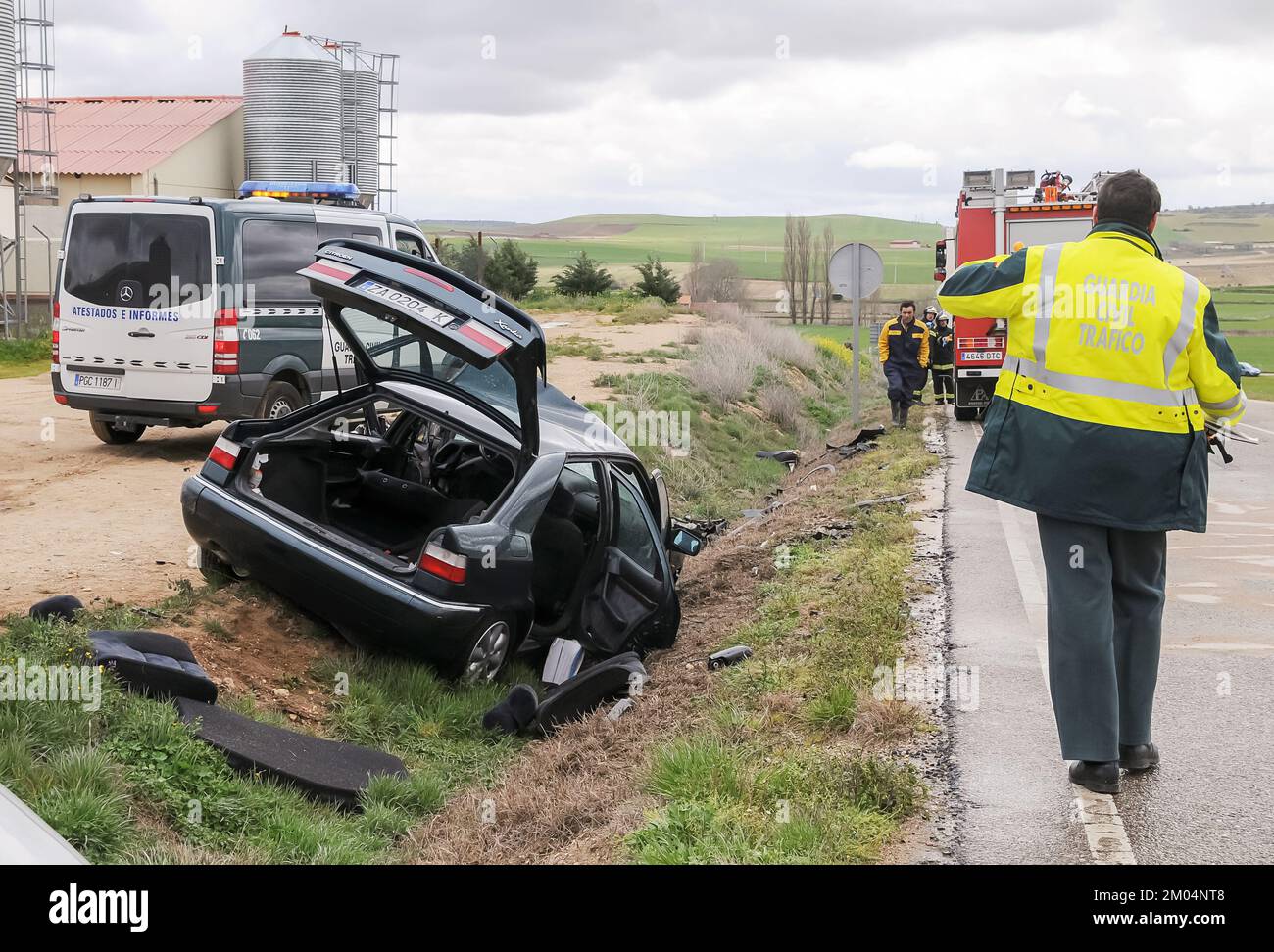 Véhicule en dehors de la route après avoir subi un accident de la circulation avec un policier de la garde civile marchant sur la route. Banque D'Images