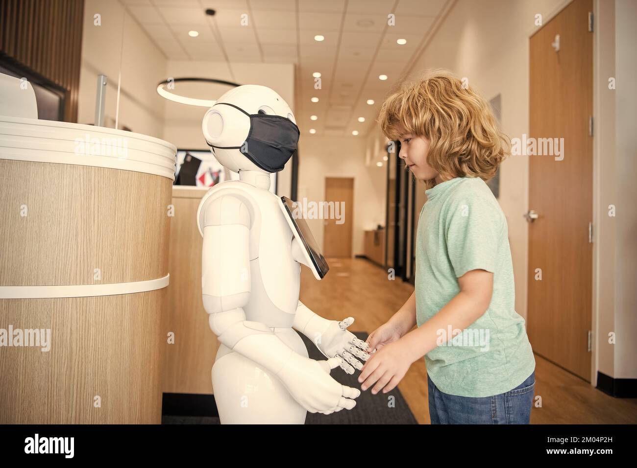 un enfant occupé interagit avec l'intelligence artificielle du robot, la communication Banque D'Images