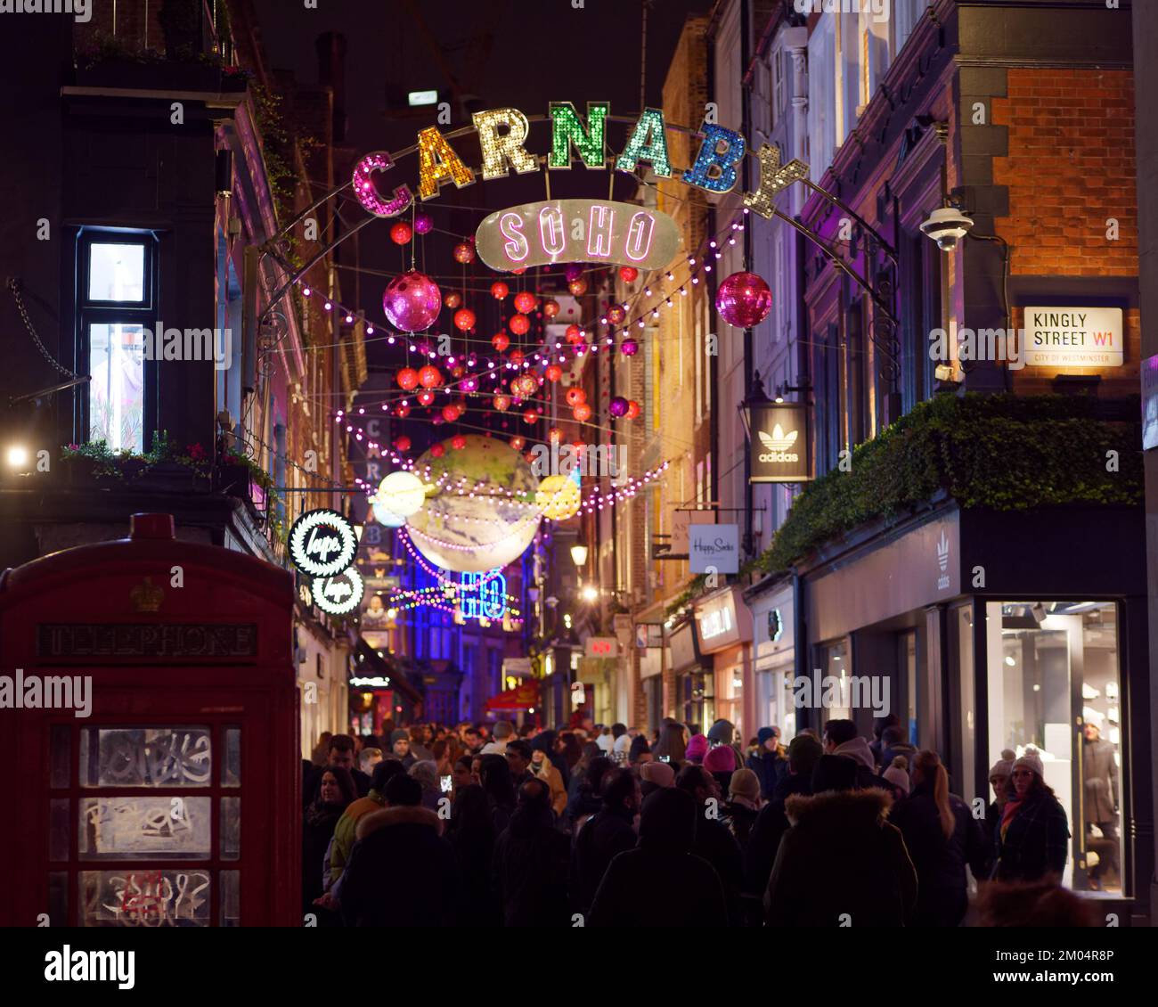 Vue sur Carnaby Street et son écran lumineux de Noël au néon la nuit, Londres. Banque D'Images