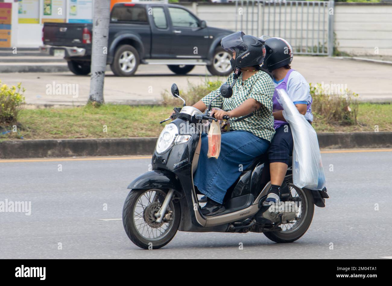 RATCHABURI, THAÏLANDE, NOVEMBRE 16 2022, deux femmes pilotant une moto avec charge Banque D'Images