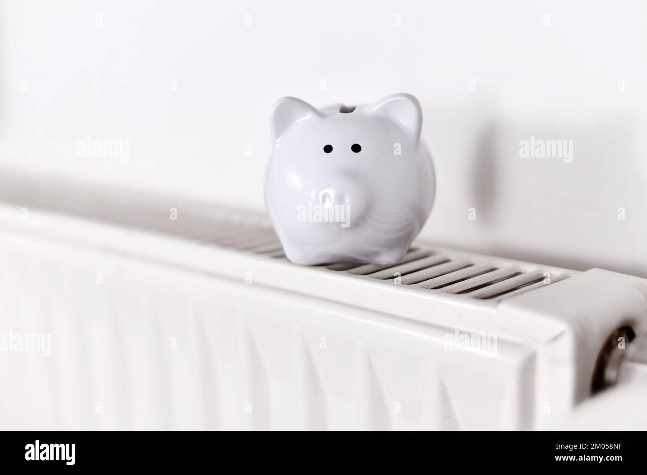Concept pour économiser de l'argent pour le gaz pour le chauffage avec banc de piggy sur radiateur avec espace de copie Banque D'Images