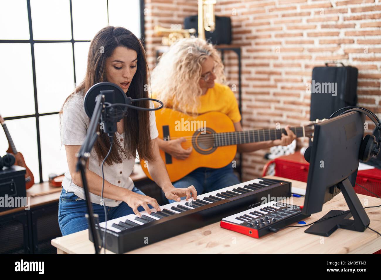 Deux femmes musiciens chantant une chanson jouant de la guitare classique  et du piano au studio de musique Photo Stock - Alamy