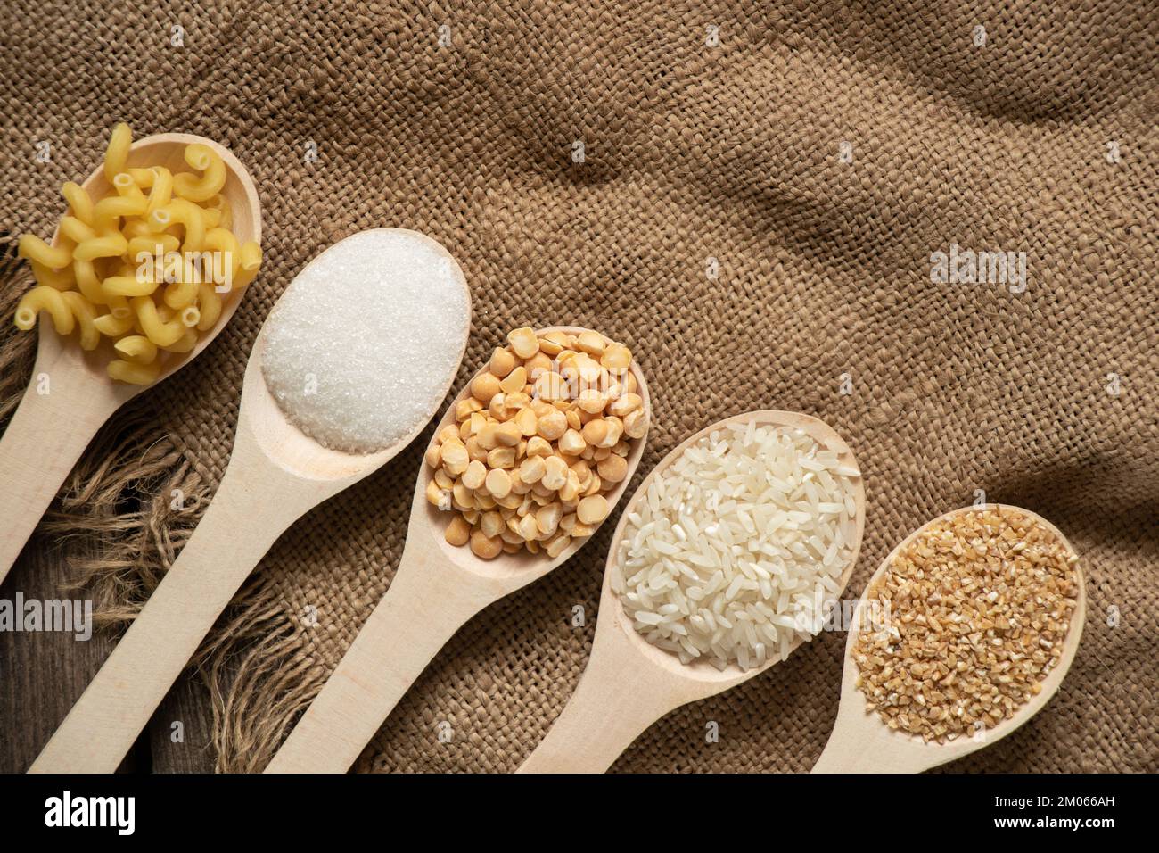 riz au sucre pois pâtes céréales sur des cuillères en bois sur la table de la cuisine, nourriture Banque D'Images