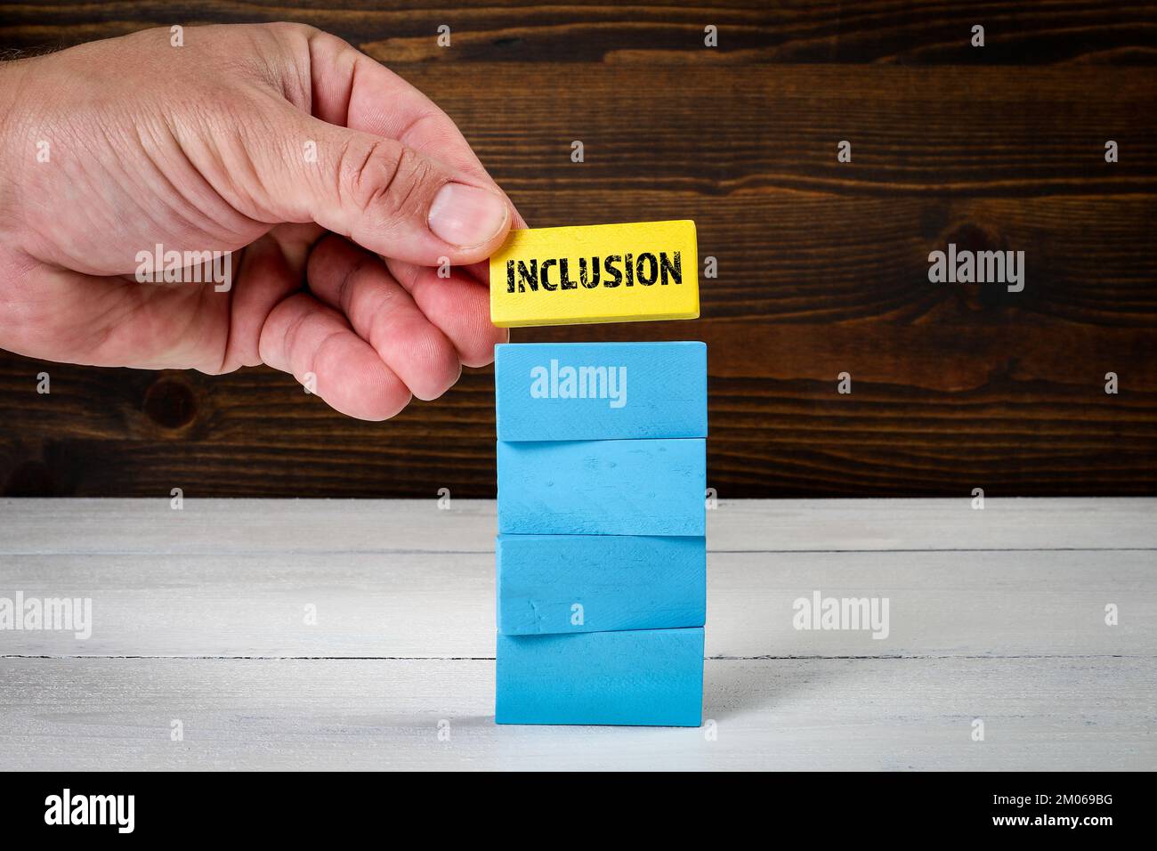 Inclusion. Blocs en bois bleu dans un tas et bloc jaune avec texte sur le dessus. Banque D'Images