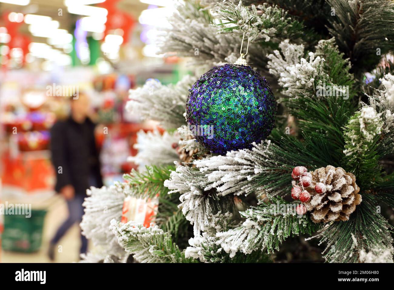 Arbre de Noël avec des jouets dans un centre commercial sur fond de personnes marchant. Décorations du nouvel an, vacances d'hiver et soldes Banque D'Images