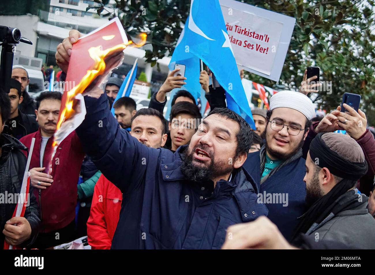 Istanbul, Turquie. 04th décembre 2022. Un manifestant brûle le drapeau chinois pendant la manifestation. Des personnes protestent contre les violations des droits de l'homme en Chine, près du consulat de Chine à Istanbul. La manifestation a pour but d'attirer l'attention sur les violations des droits de l'homme contre la minorité musulmane ouïghour dans la région chinoise du Xinjiang. Crédit : SOPA Images Limited/Alamy Live News Banque D'Images