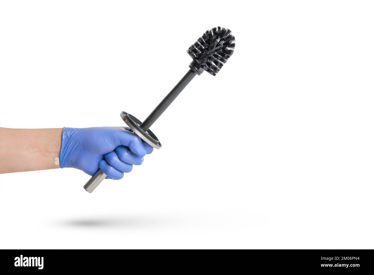 Brosse de toilette en main sur fond blanc isolé, une main dans un gant en caoutchouc bleu contient une brosse de toilette en chrome noir. Banque D'Images