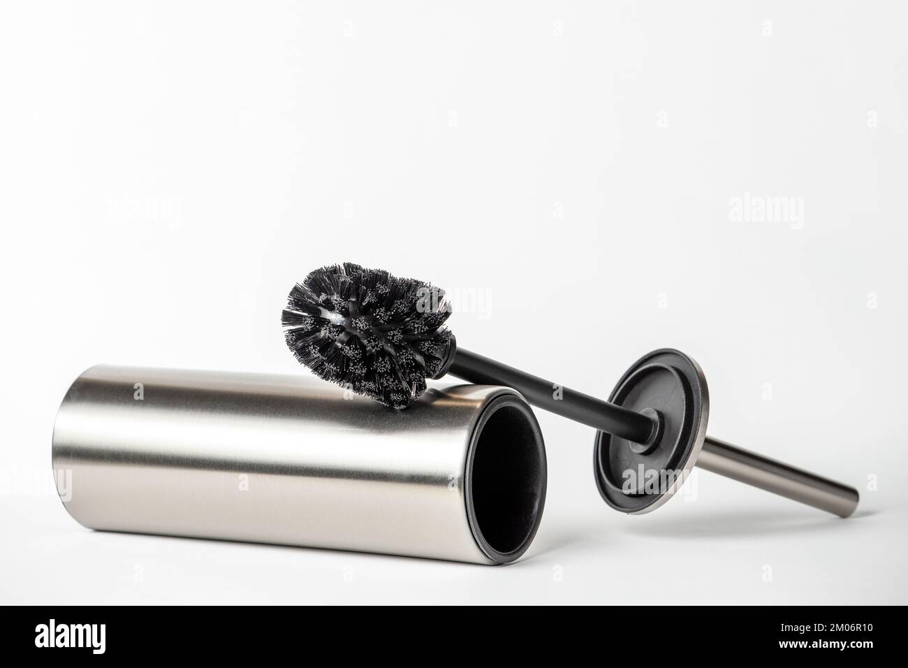Brosse de toilette noire isolée sur blanc. Gros plan d'une brosse de nettoyage de toilettes avec éléments métalliques à insérer dans un projet ou un design. Brosse métallique pour Banque D'Images