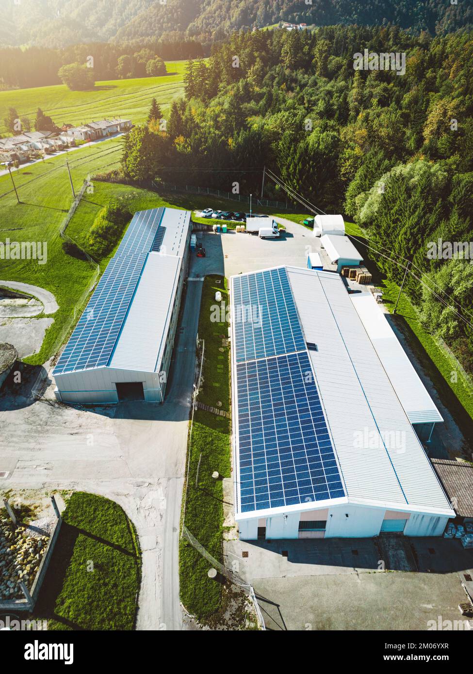 Photo verticale de deux bâtiments industriels avec un toit recouvert de panneaux solaires - énergie renouvelable Banque D'Images