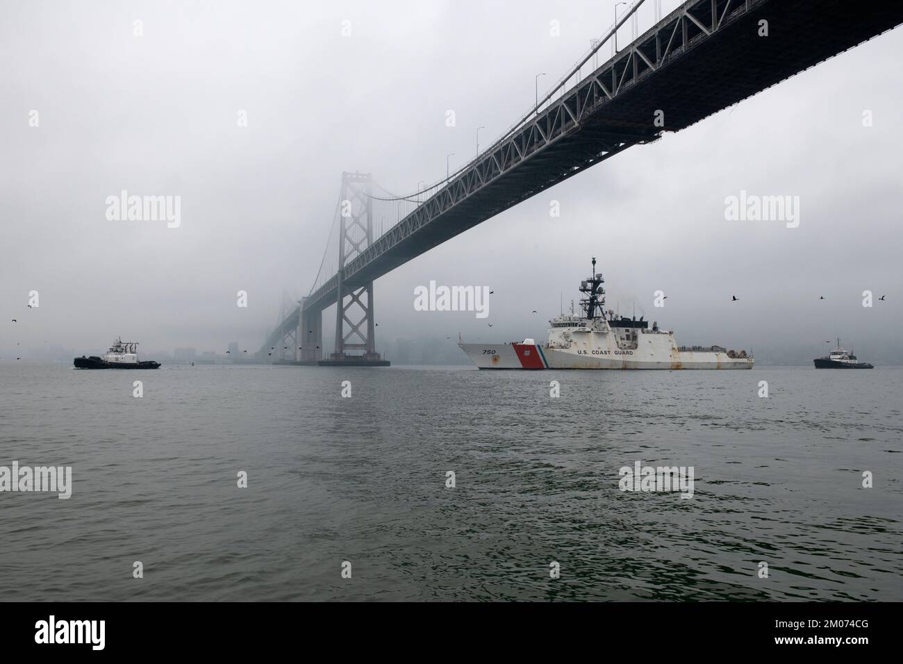 L'équipage des États-Unis Bertholf (WMSL 750), un cutter de la Garde côtière, navigue sous le pont de San Francisco - Oakland Bay tout en revenant à la base de la Garde côtière Alameda, en Californie, à la suite d'une patrouille de 77 jours contre les stupéfiants dans l'océan Pacifique oriental, le 3 décembre 2022. L’équipage de Bertholf a effectué de multiples arraisonnements de navires présumés de contrebande de drogues tout en patrouilant dans les eaux internationales au large des côtes d’Amérique centrale et du Sud, ce qui a conduit à la détention de plusieurs suspects de contrebande de drogues et à l’interdiction de plus de 1 050 livres de cocaïne. (É.-U. Photo de la Garde côtière par Petty Officer 2nd classe Matthew W. Banque D'Images