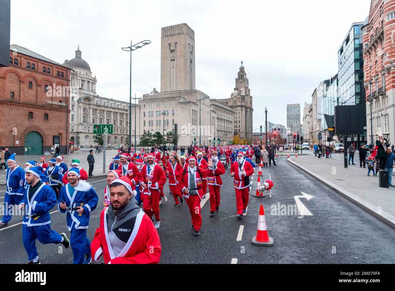 Liverpool, Royaume-Uni. 04th décembre 2022. Les coureurs font la course pendant la course annuelle de Liverpool Santa Dash. Des milliers de coureurs emportent dans les rues de Liverpool vêtus de père Noël en costume rouge et bleu de Santa lors du BTR Liverpool Santa Dash 2022, une collecte de fonds en 5k pour des organismes de bienfaisance dont l'hôpital pour enfants Alder Hey. Crédit : SOPA Images Limited/Alamy Live News Banque D'Images