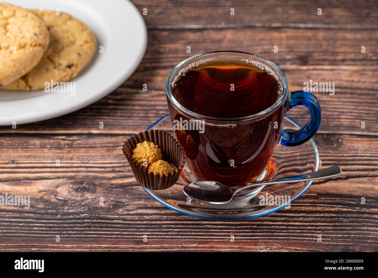 Thé turc noir dans une tasse en verre avec sablés sur une table en bois Banque D'Images