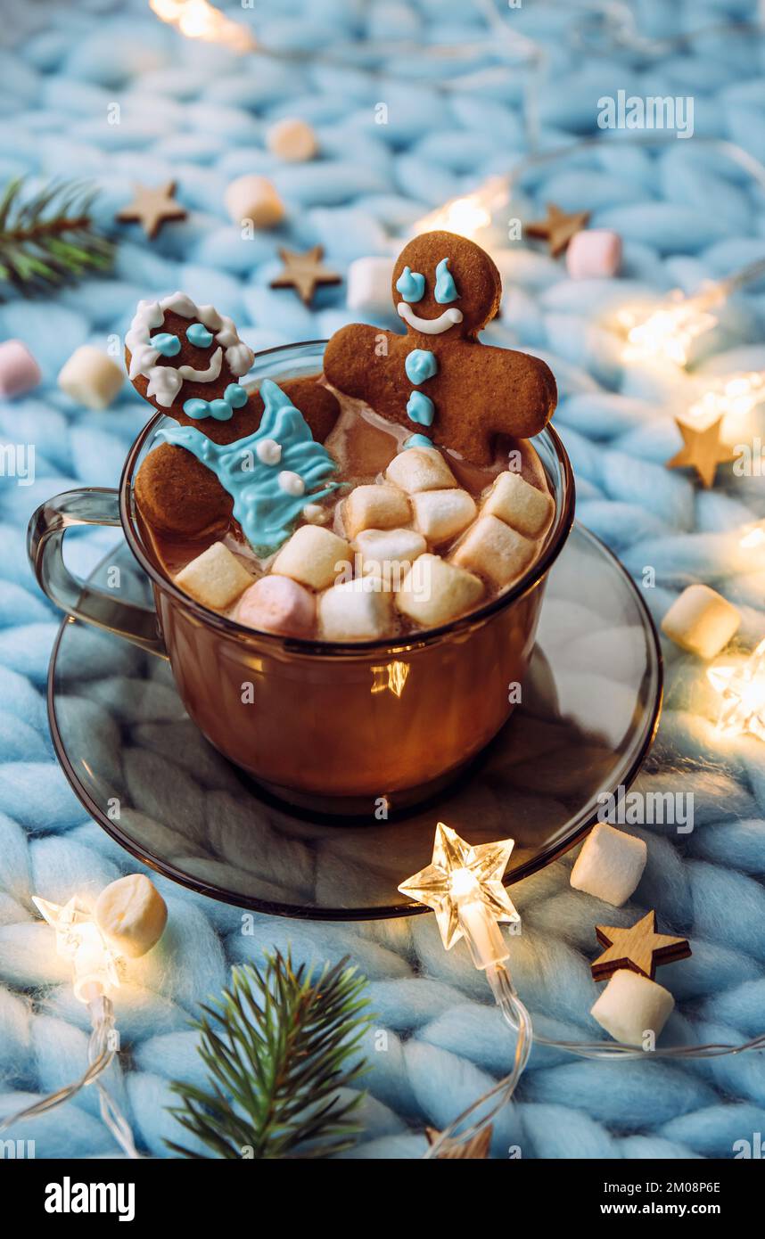 Concept de vacances de Noël spa pour couples. Couple femme et un homme fait d'un pain d'épice qui trempent dans une tasse de chocolat chaud avec guimauves, confortable. Banque D'Images