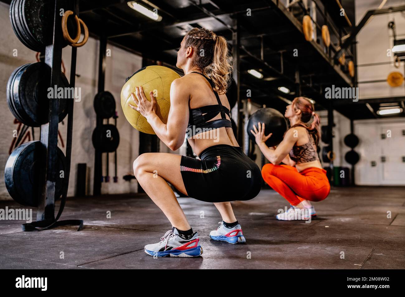 Les femmes faisant de l'exercice avec la médecine lourde balle dans la salle de gym Banque D'Images