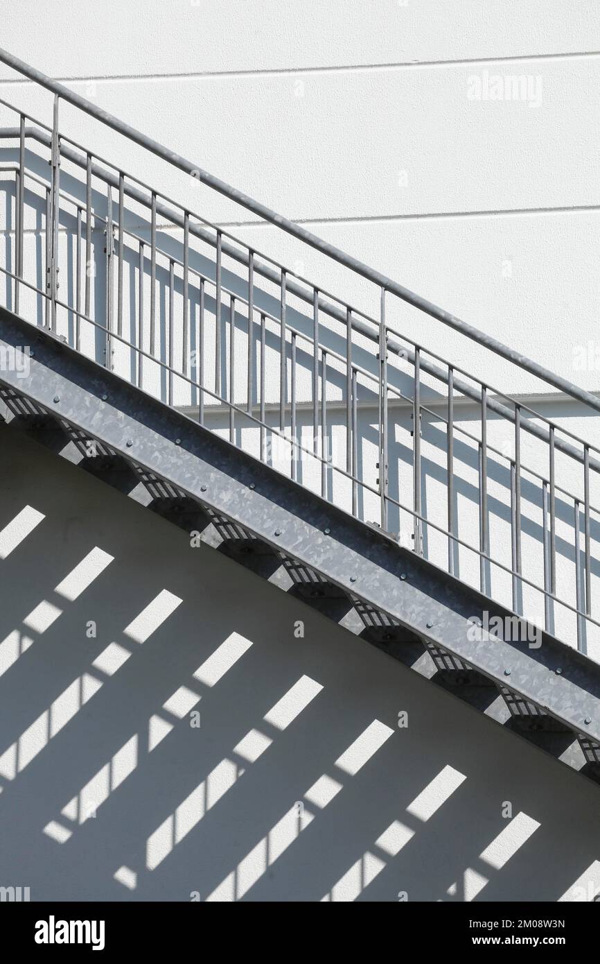 Escalier extérieur en acier avec ombre sur un mur blanc de maison, Allemagne, Europe Banque D'Images