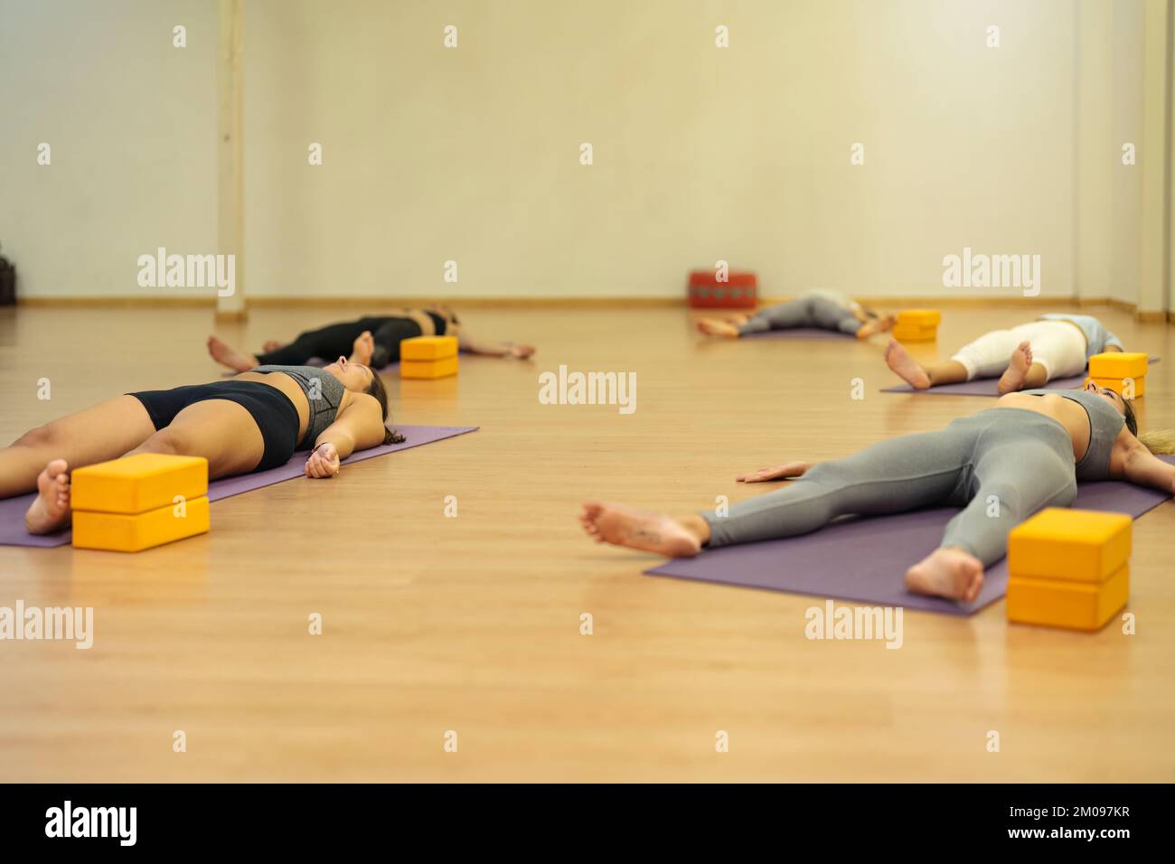 groupe de femmes allongé en se relaxant à la fin du cours de yoga Banque D'Images