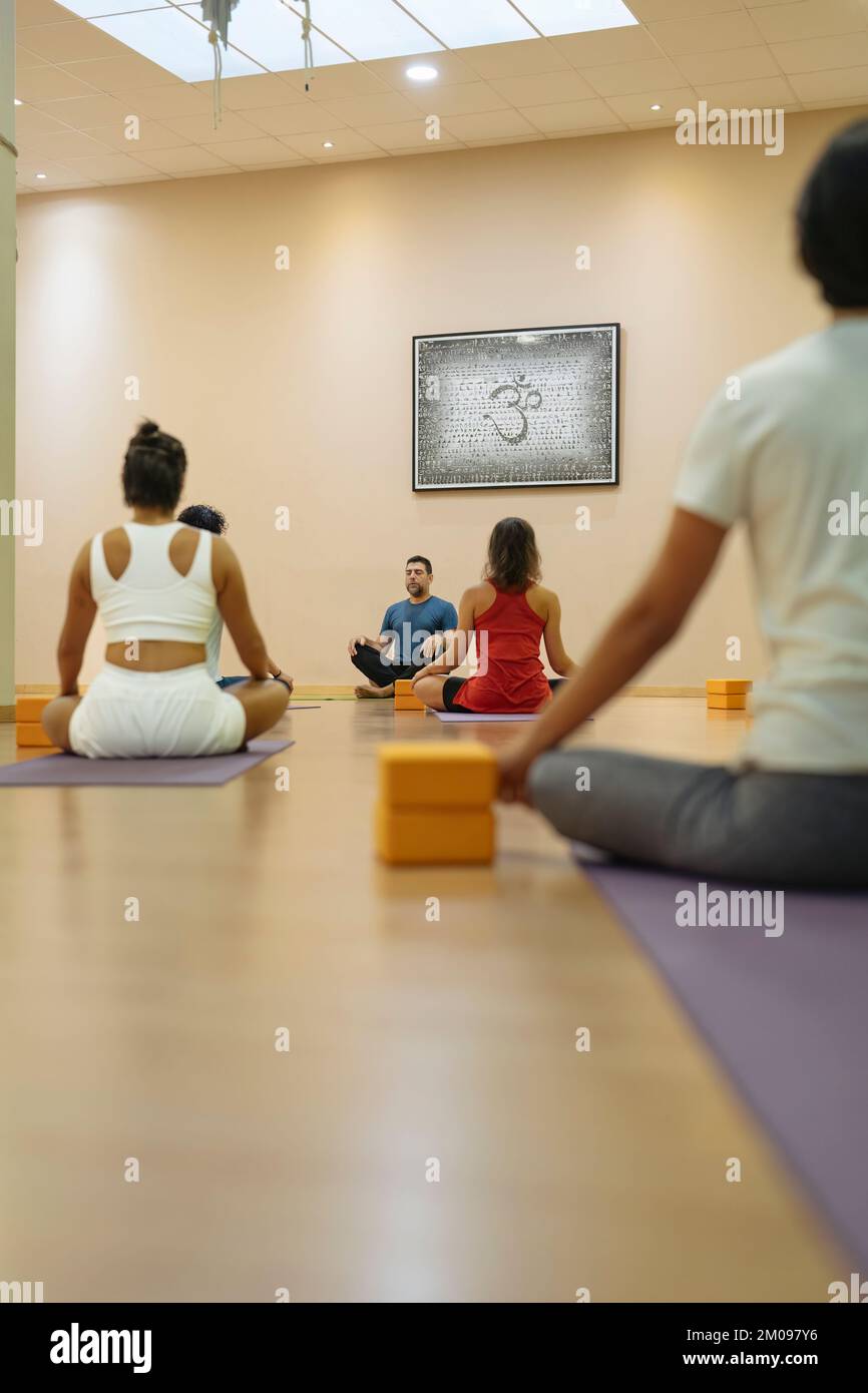Professeur de yoga enseignant d'enseigner une classe à Sukhasana pose Banque D'Images