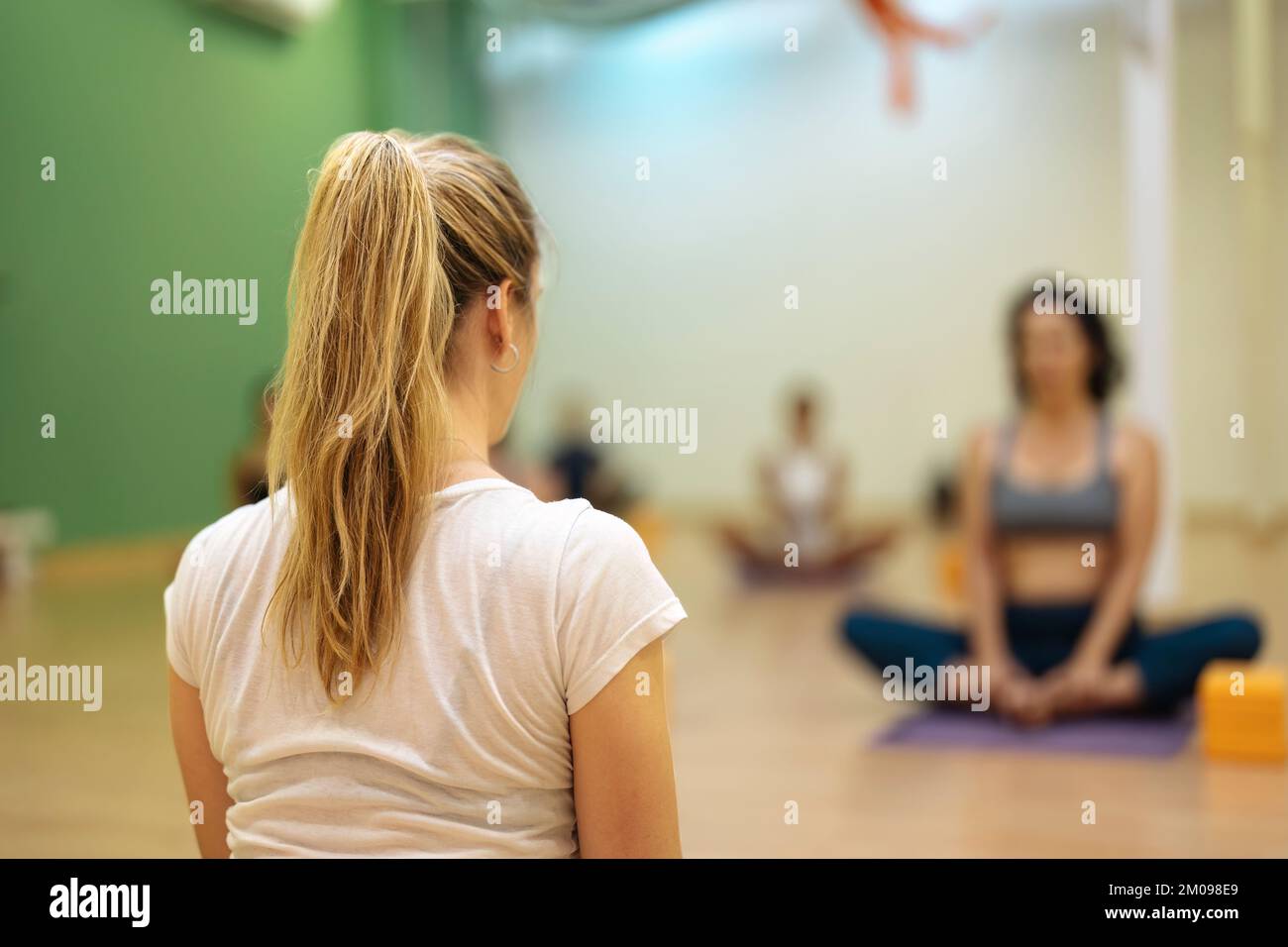 vue arrière du professeur de yoga blond pendant les cours Banque D'Images