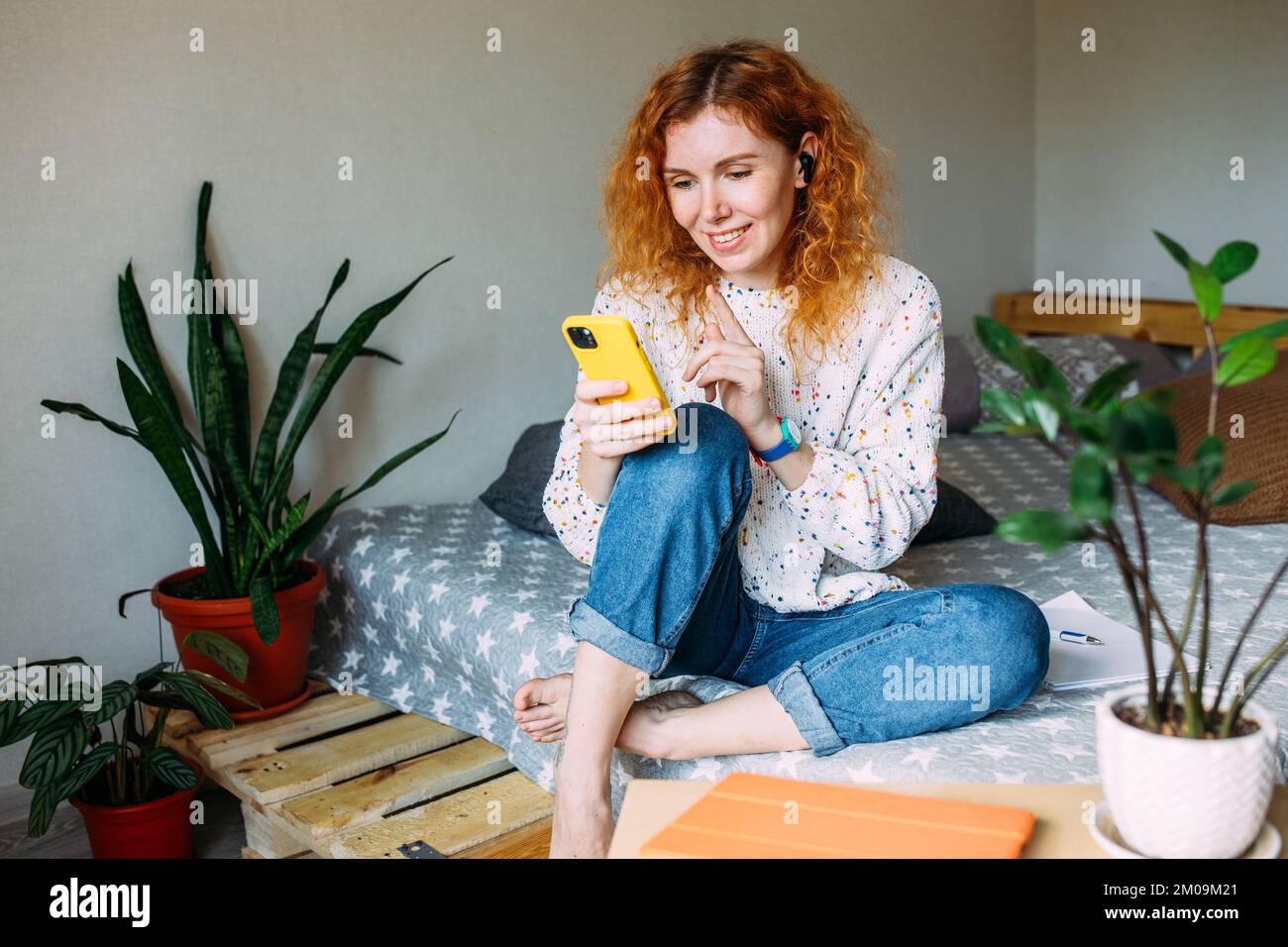 Jeune femme parlant sur un smartphone depuis sa maison lors d'un appel vidéo Banque D'Images