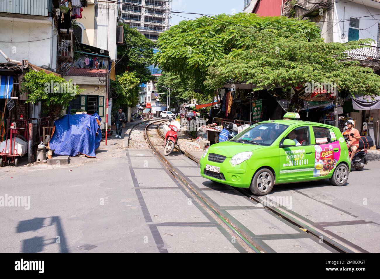 Hanoï, Vietnam - 16 septembre 2018: Taxi avec la publicité traverse la voie de train qui traverse la ville de Hanoï, manque de sécurité routière Banque D'Images