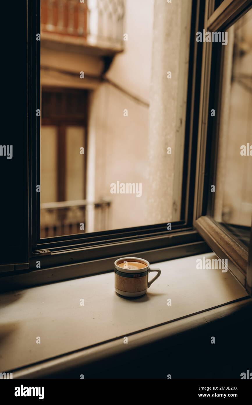 Tasse de café près de la fenêtre avec des volets à Turin, Italie. Profitez d'un moment de détente et d'un style de vie. Un jour de soleil confortable. Vibes du week-end Banque D'Images