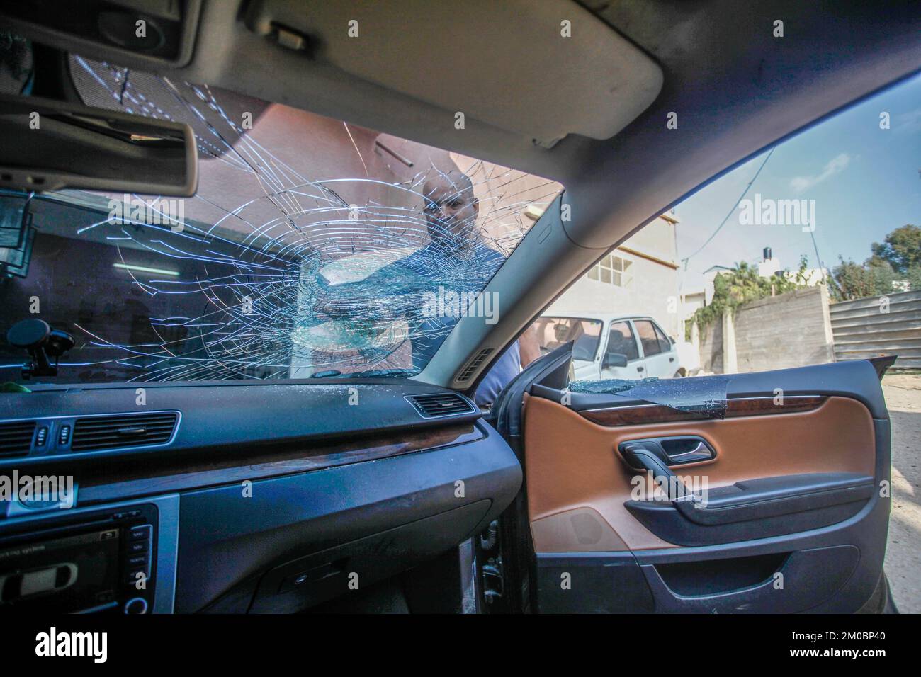 Naplouse, Palestine. 05th décembre 2022. Le palestinien Mohammed Odeh, 54 ans, inspecte sa voiture détruite après que les colons lui ont lancé des pierres près de Hawara, au sud de Naplouse, en Cisjordanie. Odeh dit que quatre colons juifs ont jeté des pierres sur sa voiture et l'ont battu, lui et sa femme, les blessant. Crédit : SOPA Images Limited/Alamy Live News Banque D'Images