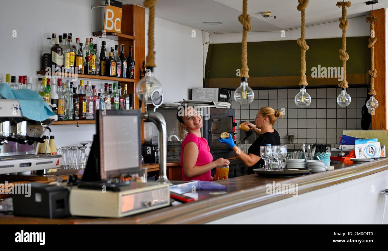 Des gens heureux travaillant dans le café de l'océan bleu derrière le comptoir, San Agustín, Las Palmas, Gran Canaria Banque D'Images Des gens heureux travaillant dans le café de l'océan bleu derrière le comptoir, San Agustín, Las Palmas, Gran Canaria Banque D'Images