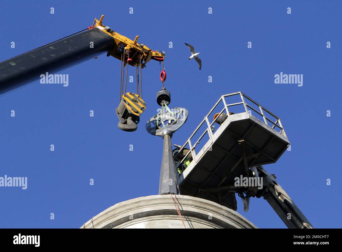 DNIPRO, UKRAINE - 5 DÉCEMBRE 2022 - les travailleurs retirent l'étoile à cinq pointes, l'un des symboles soviétiques, de la flèche qui couronnait le toit d'un bâtiment i. Banque D'Images