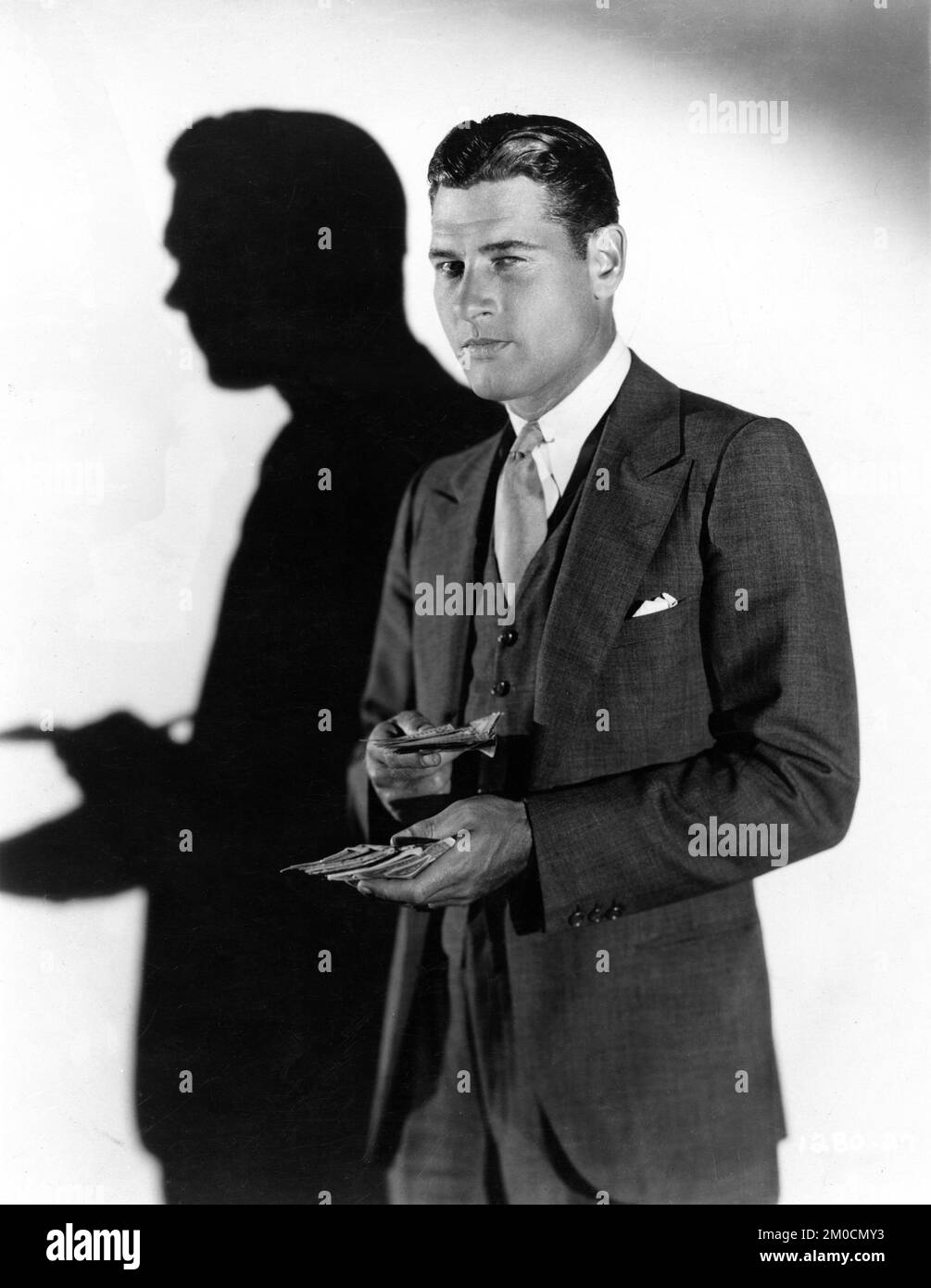 RICHARD ARLEN portrait de publicité avec des billets en dollars seulement travail SAPS 1930 réalisateurs CYRIL GARDNER et EDWIN H. KNOPF jouer Owen Davis scénario Percy Heath Sam Mintz et Joseph L. Mankiewicz éditeur de film Edward Dmytryk Paramount Pictures Banque D'Images