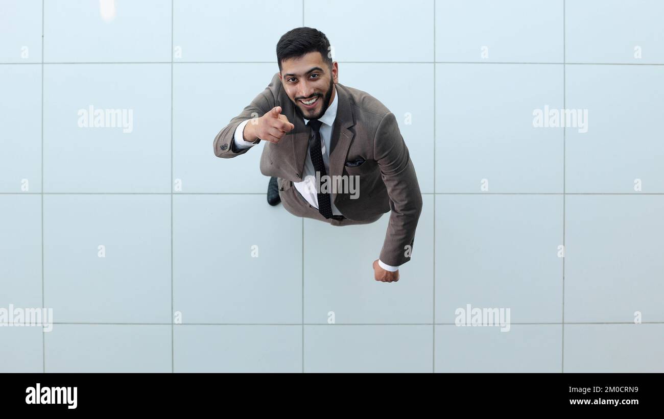 Beau homme d'affaires souriant dans un costume debout avec ses bras croisés. Banque D'Images